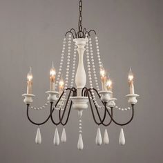 a white chandelier with pearls hanging from it's center and five lights on each end