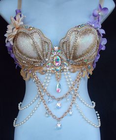 a woman wearing a bra with pearls and flowers on it