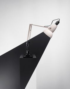 a desk lamp sitting on top of a black stand with a white light bulb attached to it