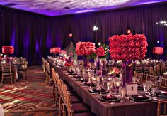 a long table is set with flowers and place settings for an event or function in the ballroom