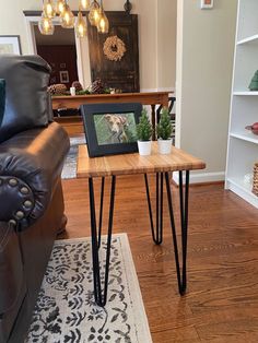 a small table with some hairpinks on it and a picture frame in the middle