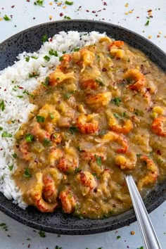 a black plate with rice and shrimp on it