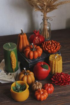 a wooden table topped with pumpkins, corn and other fall decorations on top of it