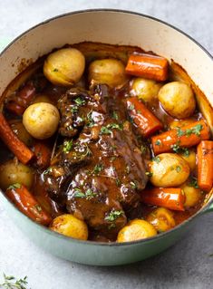 a pot roast with carrots, potatoes and gravy is shown in the foreground