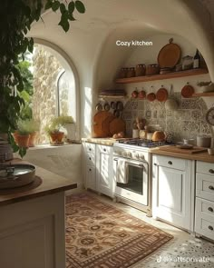 a kitchen with an arched window and lots of pots on the stove top, sink, and cabinets