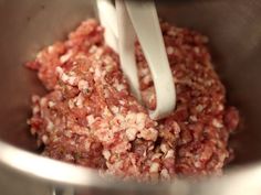 a metal bowl filled with meat and milk