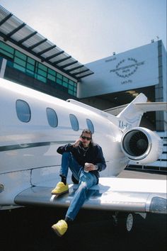 a man sitting on the nose of an airplane