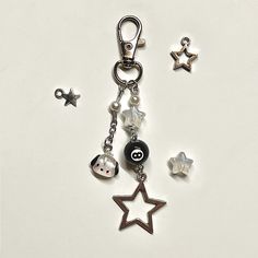 a keychain with charms attached to it on a white surface next to other items