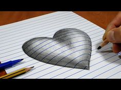 someone drawing a heart on lined paper with pencils and crayon markeres