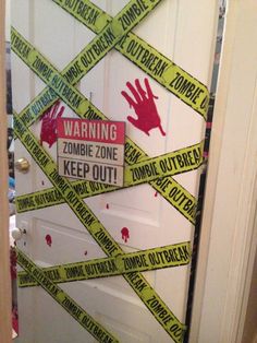 a door decorated with yellow caution tape and red handprints on the side, warning zombie zone keep out