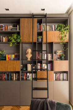 a living room with bookshelves and ladders to the ceiling, filled with plants