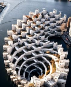 an aerial view of a building complex in the middle of a body of water with buildings surrounding it