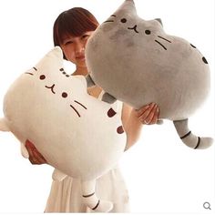 a woman holding a large stuffed cat in her hands