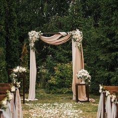 an outdoor ceremony set up with white flowers and greenery