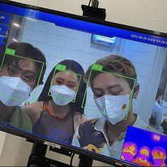 three people wearing face masks are shown on a flat screen tv with an x - ray