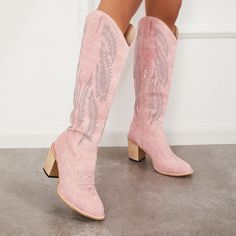 a pair of pink cowboy boots with floral embroidered on the side and heeled soles