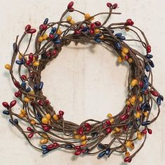 a close up of a wreath made out of branches with colored beads on top and bottom