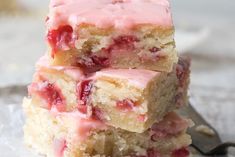 three pieces of strawberry shortcake stacked on top of each other next to a fork