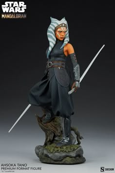 a star wars figurine is posed on top of a rock with two swords