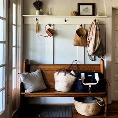 a wooden bench sitting in front of a window filled with purses and handbags