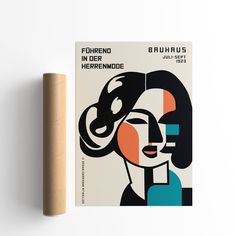 a book with an image of a woman's face on it and a wooden tube next to it