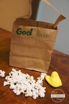 a bag full of popcorn sitting on top of a table next to a pile of small pieces of food