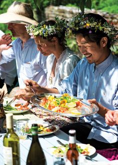 several people sitting at a table with plates of food