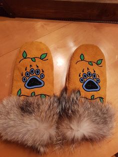 a pair of furry slippers with an image of a dog's paw on it