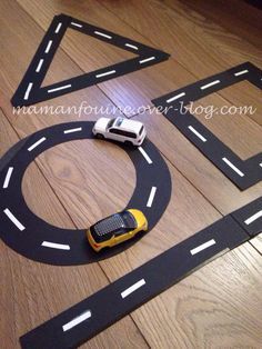 a toy car is on the road made out of cardboard tape and plastic construction blocks