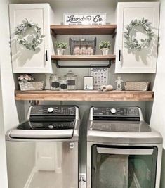 a washer and dryer in a small room with white cupboards on the wall