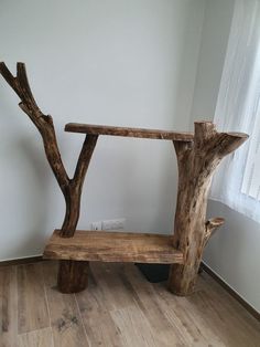 a wooden bench sitting on top of a hard wood floor in front of a window