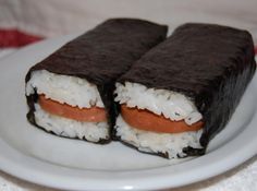 two pieces of sushi on a plate with white rice and carrots in it