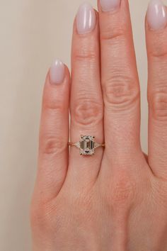 a woman's hand with a ring on it and a diamond in the middle