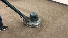 a man is using a floor scruber on the carpet