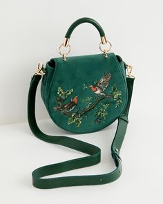 Key Features



Embroidered Elegance: Adorned with intricate embroidery depicting two facing robins on a branch, symbolizing luck, happiness, and rebirth.


Luxurious Velvet: Crafted from sumptuous fern green velvet, this saddle bag offers a rich texture and sophisticated appearance.


Functional Design: Designed for practicality with a rounded silhouette, top handle, and adjustable cross-body strap for easy carrying.


Secure Closure: Features a magnetic fastening to keep your essentials saf Fable England, Saddle Handbags, Stocking Fillers For Her, Hand Painted Jewelry, Fern Green, Forever Jewelry, Jewelry Ring Box, Gorgeous Bags, Saddle Bag