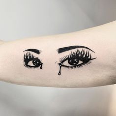 a woman's arm with black eyeliners and teary lashes on it