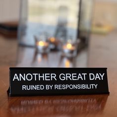 there is a sign that says another great day ruined by resonsibility on the table