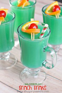 three glasses filled with green liquid and fruit on sticks