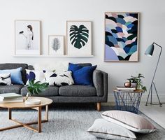 a living room filled with furniture and pictures on the wall above it's coffee table