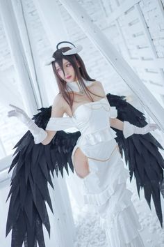 a woman dressed in white with black wings