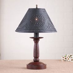 a table lamp with a blue shade on it sitting on top of a wooden table