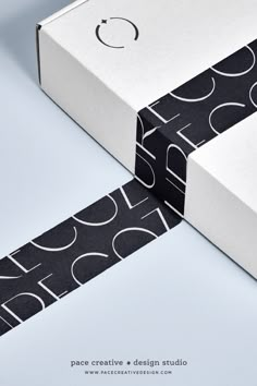 two boxes with black and white designs on them, one is open to reveal the packaging