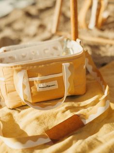 a yellow and white bag sitting on top of a beach