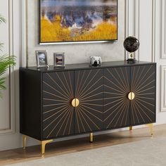 a black and gold sideboard in a living room with a painting on the wall