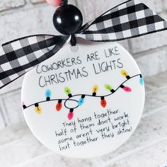 a christmas ornament hanging from the side of a brick wall that says, co workers are like christmas lights they hung together half of them don't