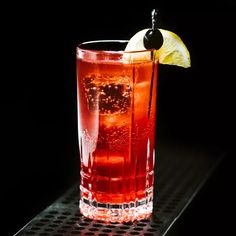 a tall glass filled with ice and a lemon wedge on top of it's side