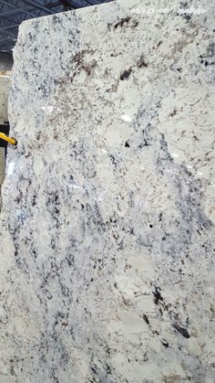 a marble slab is being worked on by a man with a yellow safety harness in front of it