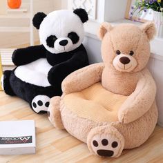 two stuffed animals sitting on chairs in front of a window, one is black and the other is white