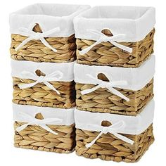 four wicker baskets with white handles are stacked on top of each other in the same pattern