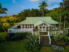 an aerial view of a house surrounded by trees and shrubs with stairs leading up to it